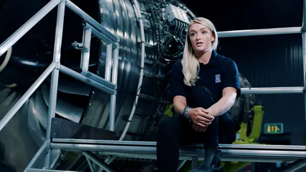 Female engineering production manager, next to an airplane engine