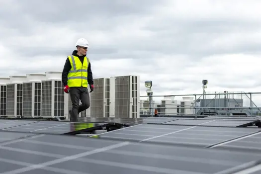 Male apprentice engineer inspecting solar panels