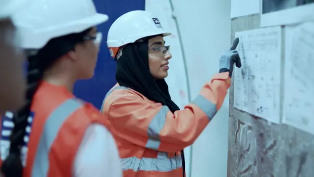 Female civil engineers discussing ideas around wall plan