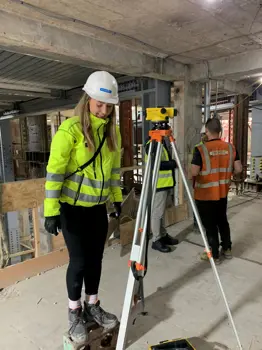 Brogan MacDonald, Head of Sustainability in Building Structures at Ramboll, using surveying equipment on site.