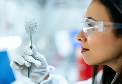 Female chemical engineer, holds up invention in laboratory