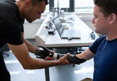 Robotics engineer fitting a prosthetic arm