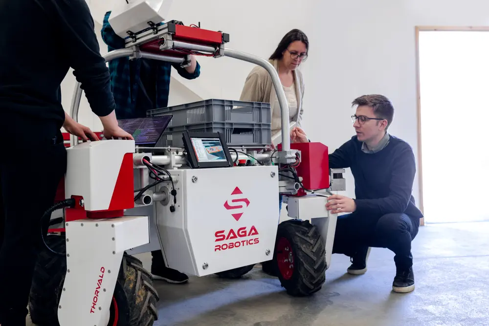 Mechanical engineers inspecting an agricultural robotic.