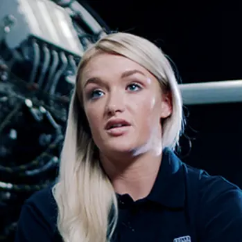 Bethan Murray, female engineering production manager, next to an aircraft engine