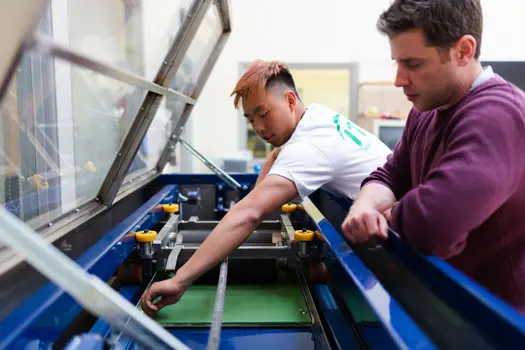 Male sports engineers conduct experiments on tennis equipment