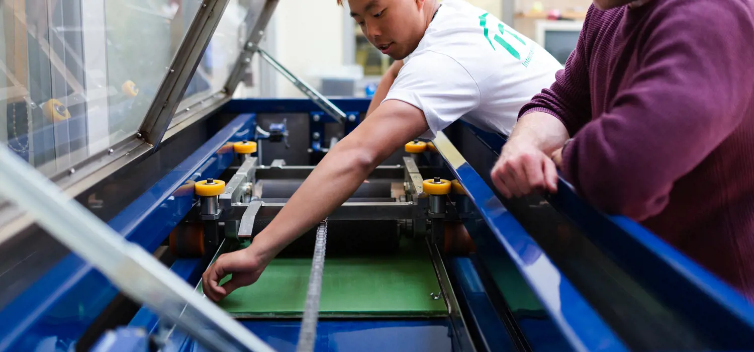 Male sports engineers conduct experiments on tennis equipment