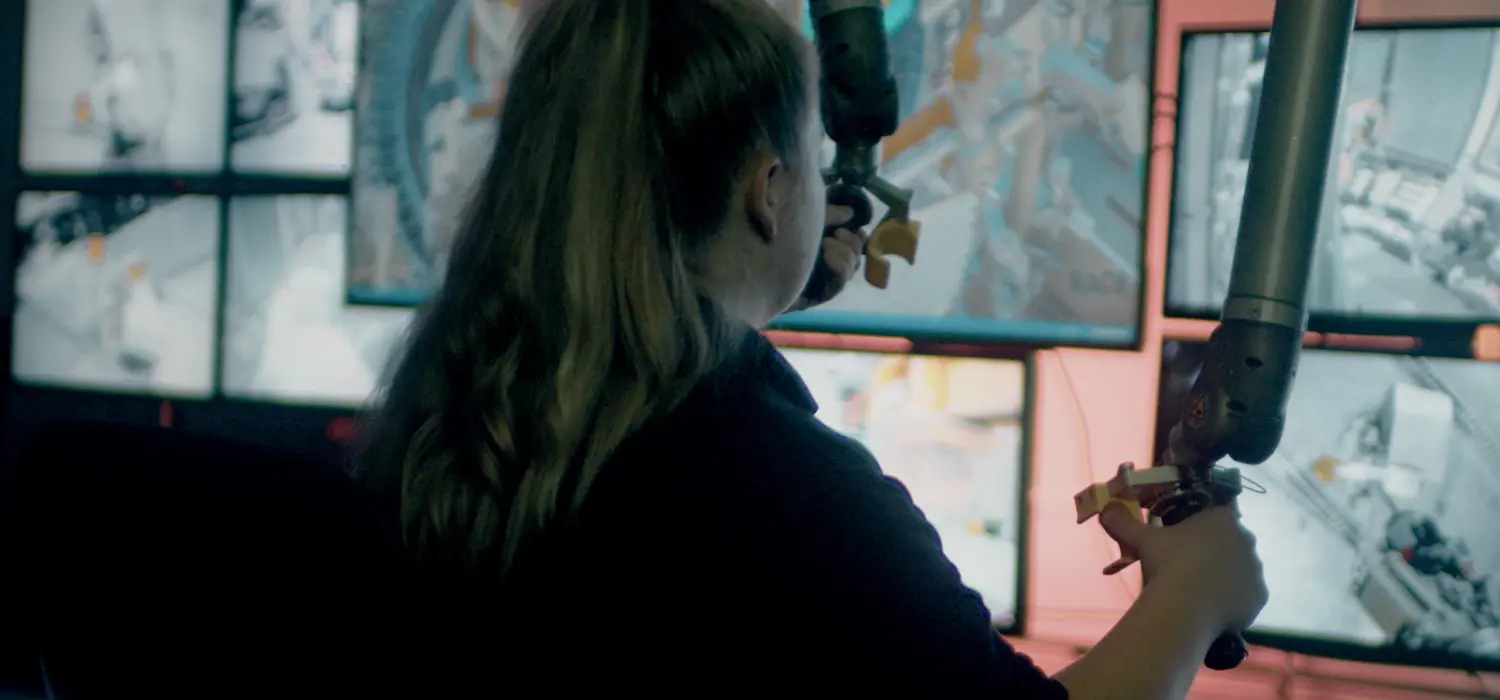 Female apprentice mechanical engineer uses robot